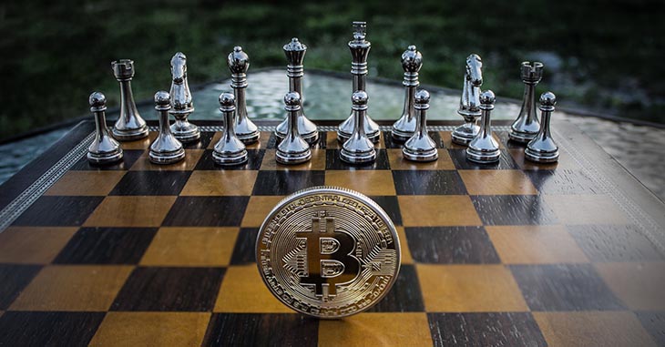 Picture of chess board with Bitcoin token to accompany article about Kasparov's opinions on cryptocurrency