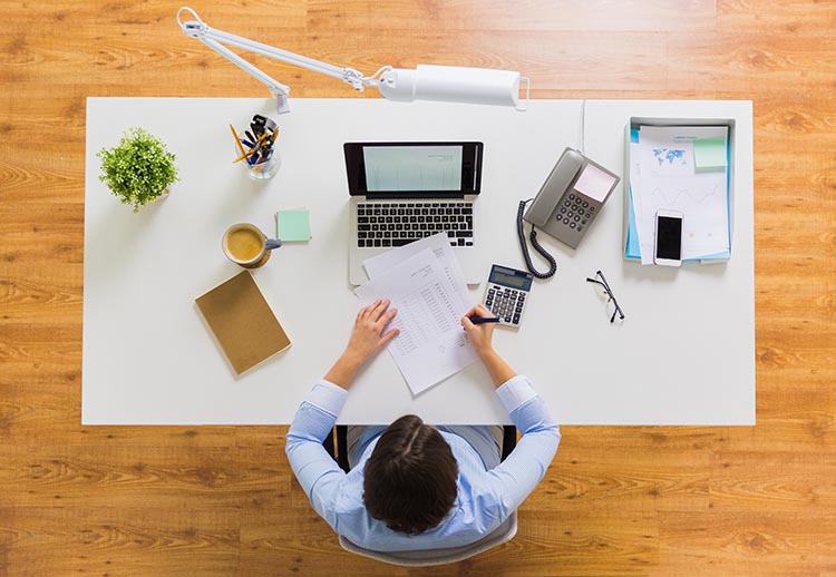 business person sitting at a desk with computer doing their taxes